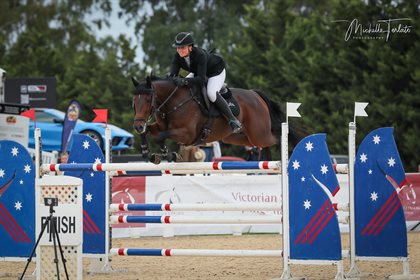 Georgia Bouzaid smiles as she clears the final jump to win the Young Rider Championship with AP Ninja. © Michelle Terlato